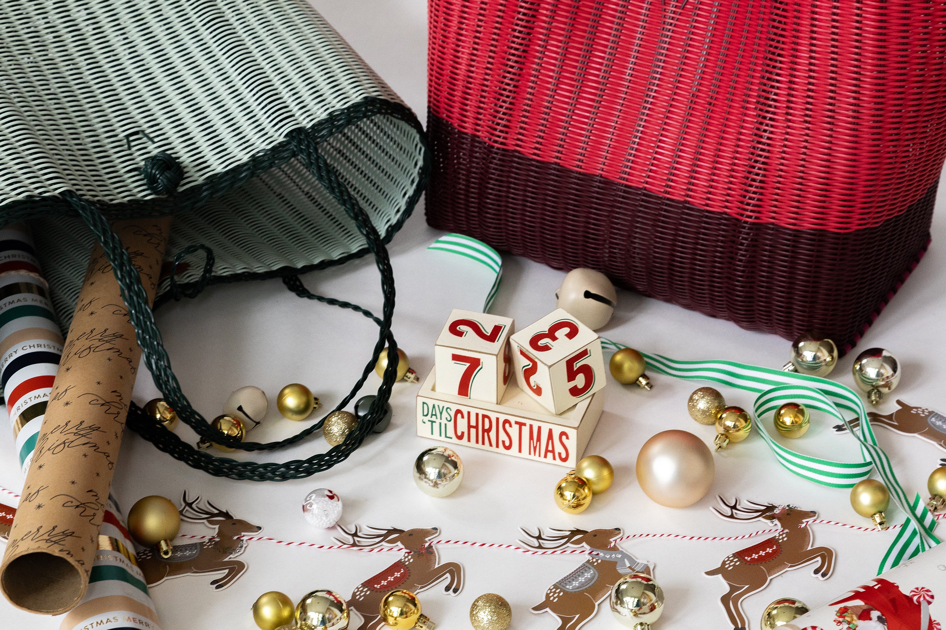 A vibrant red and white woven bags embellished with bells, prominently displaying a playful reindeer.