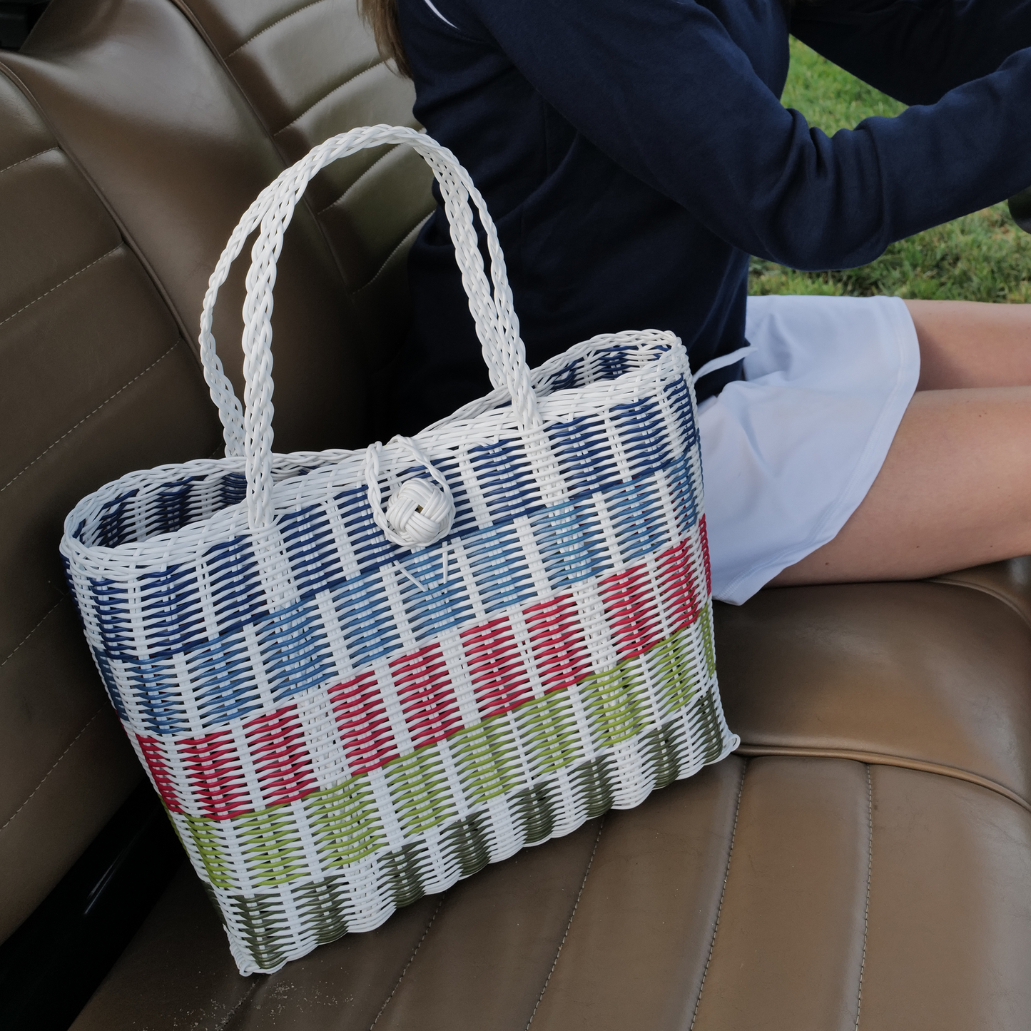 Colorful woven bag on a brown leather surface