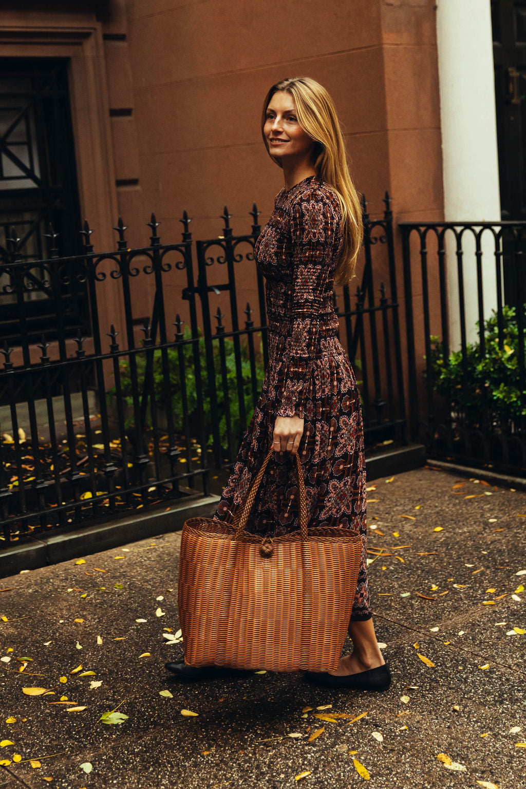 Woman holding a brown leather bag in an urban setting